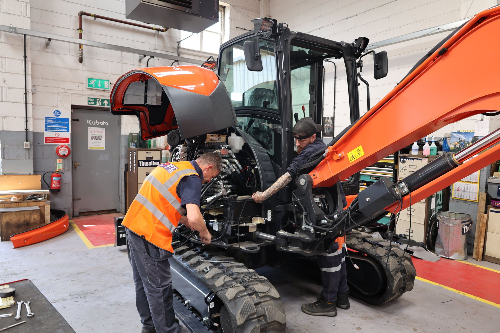 two service engineers working on a kubota excavator in the workshop at BTE