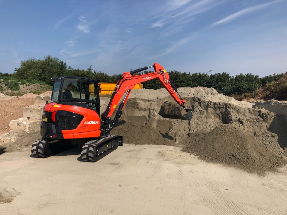 Kubota KX060-5 on site collecting material from a pile Kubota KX060-5 on site collecting material from a pile