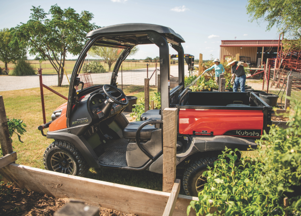 Kubota RTV 520 orange 2 seater in a garden with two workers