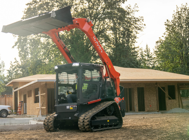 Kubota SVL75-3 on site bucket up house in background Kubota SVL75-3 on site bucket up house in background