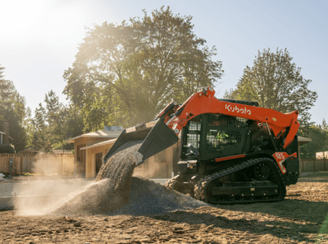 Kubota SVL75-3 on site pouring gravel from bucket