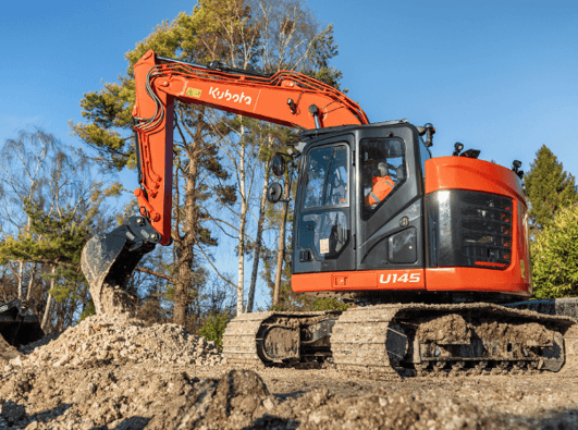 Kubota U145 left side emptying bucket of rubble