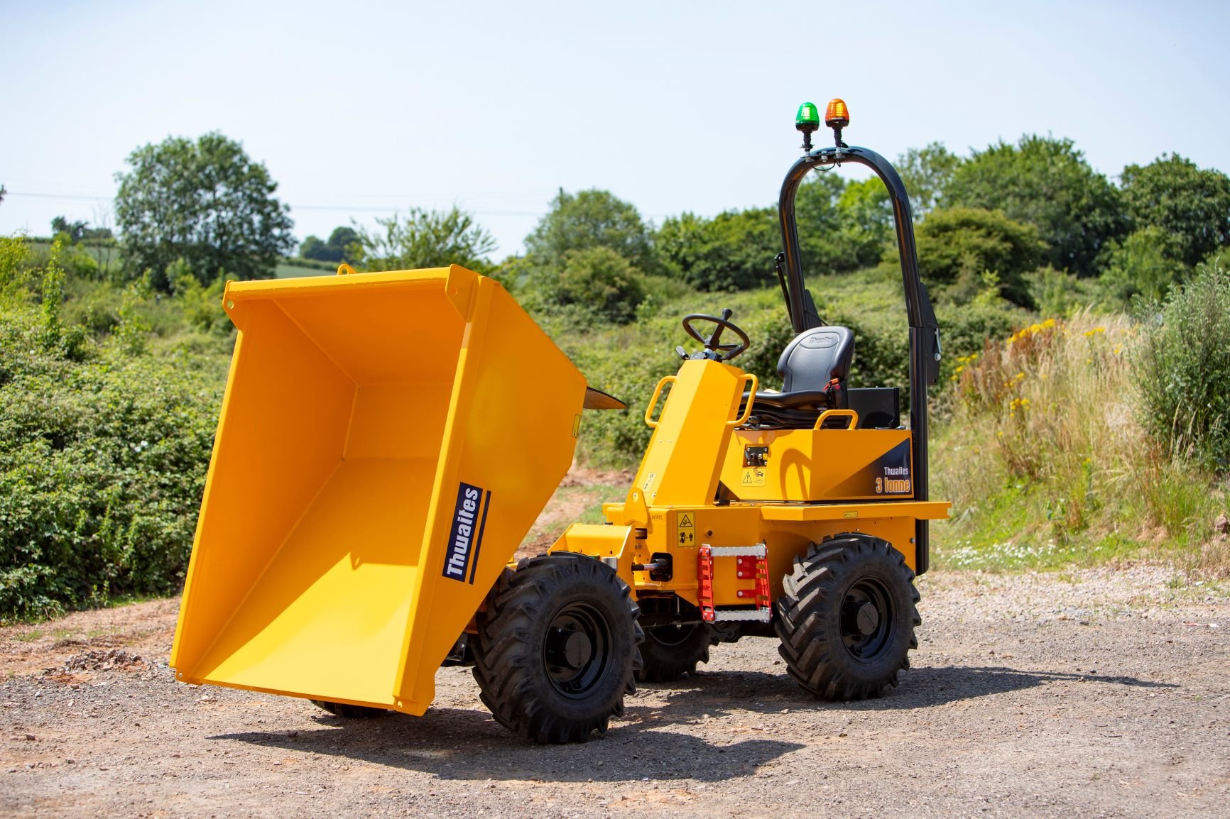 Thwaites 3 tonne front tip dumper with the skip tipped forward. Dumper is on an angle to the camera