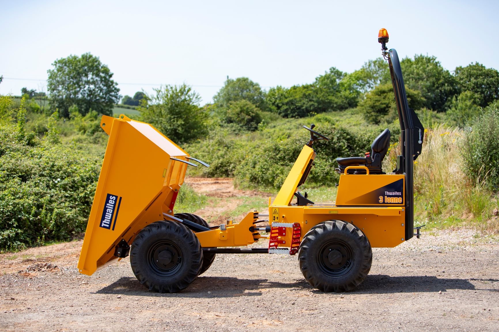 Thwaites 3 tonne front tip dumper, facing left with skip tipped forward