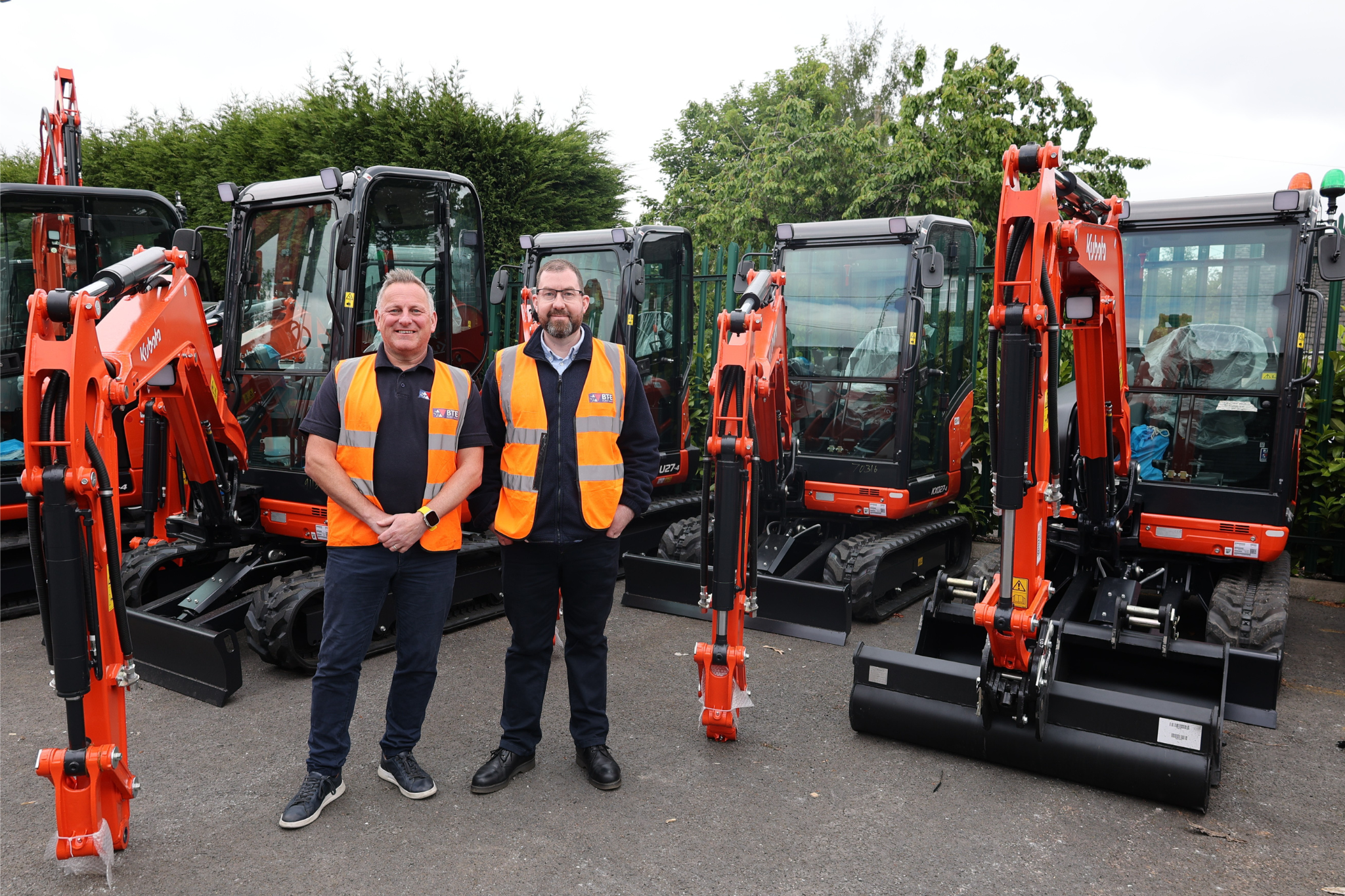 Matt Robins, Group Parts Manager and Adam Goodwin, Group Aftersales Manager pose in front of some Kubota Excavators