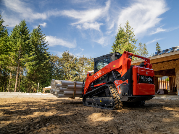 Kubota skid steer svl75-3 from the rear carrying pipes