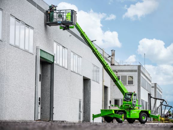 Merlo ROTO50.30S PLUS rotating telehandler with a man basket attached and stabilisers down. 