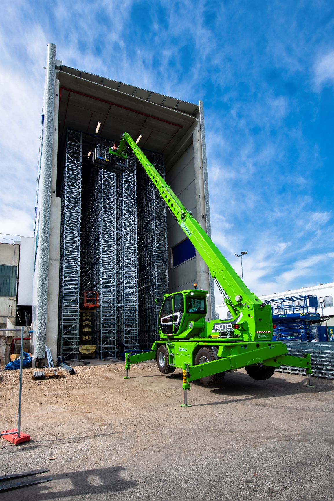 MERLO ROTO50.26S PLUS rotating telehandler with a man basket attached, stabilisers out. Working on site