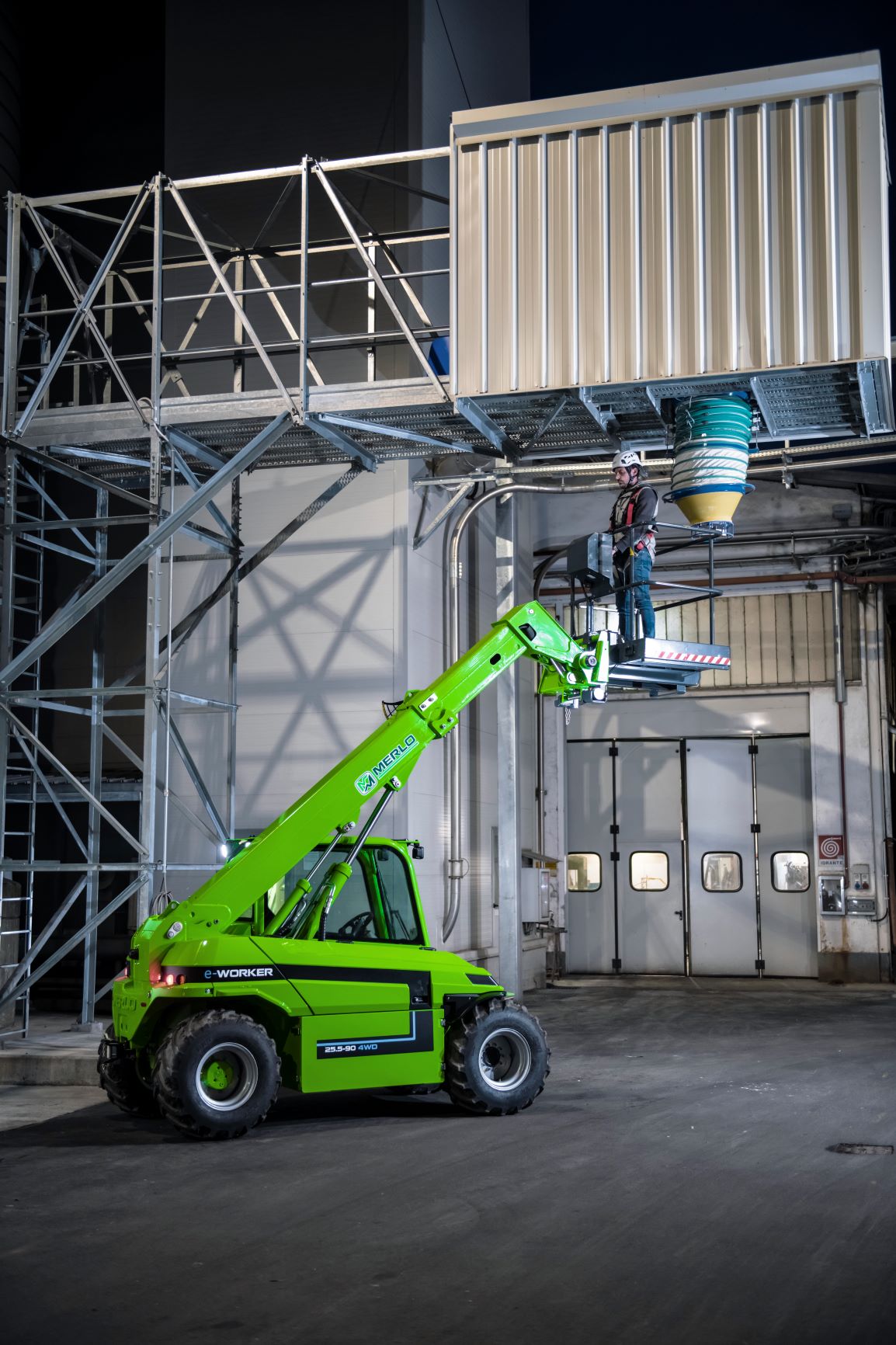 The Merlo eWorker 25.5 90 electric telehandler. Man basket attached and a man standing in it to operate. 