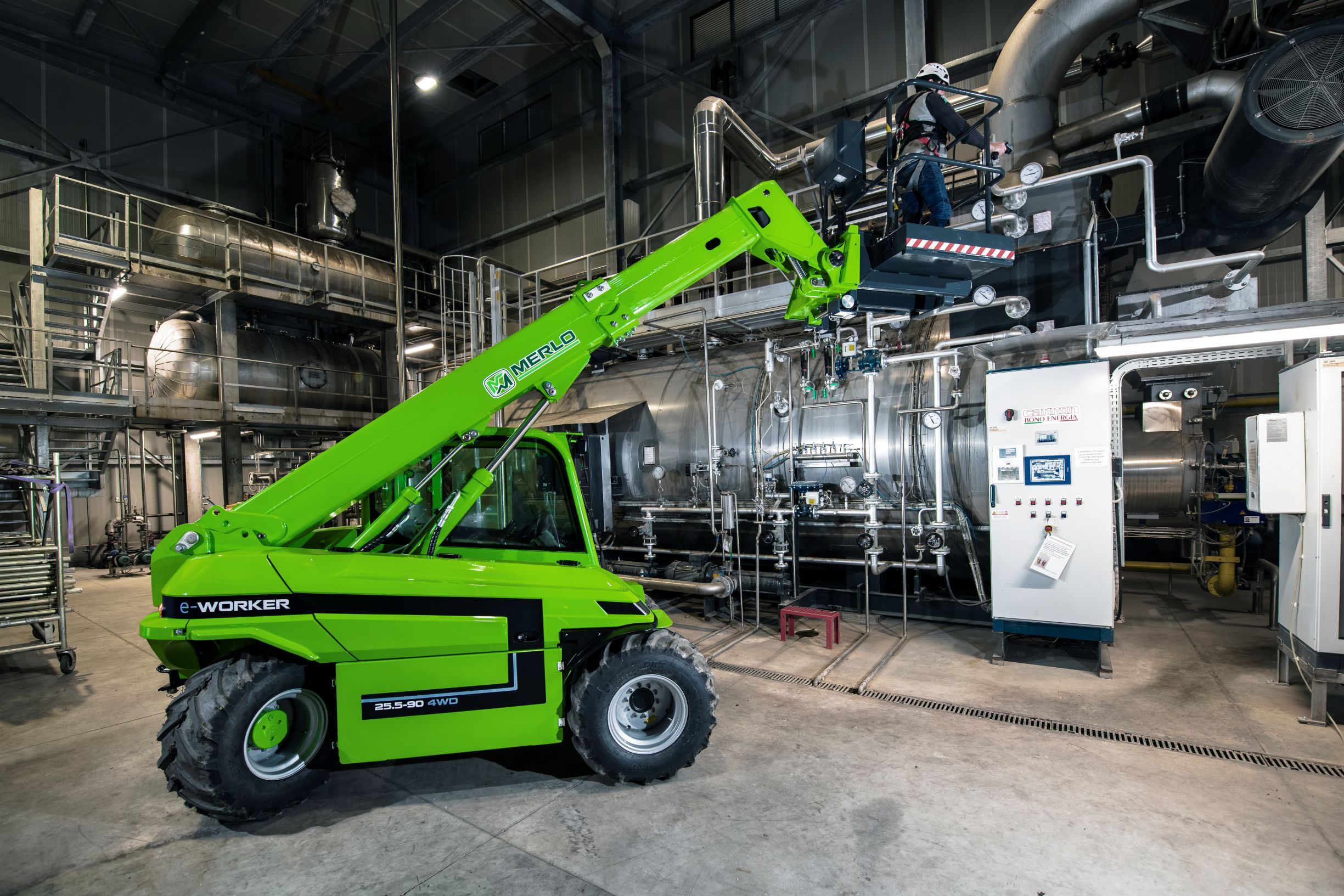 The Merlo eWorker 25.5 90 electric telehandler. With man basket attached. Operating inside a warehouse.