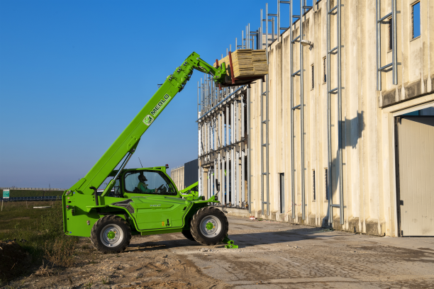 Merlo P40.17 stabilised telehandler with part extended boom lifting a pallet to a two story roof