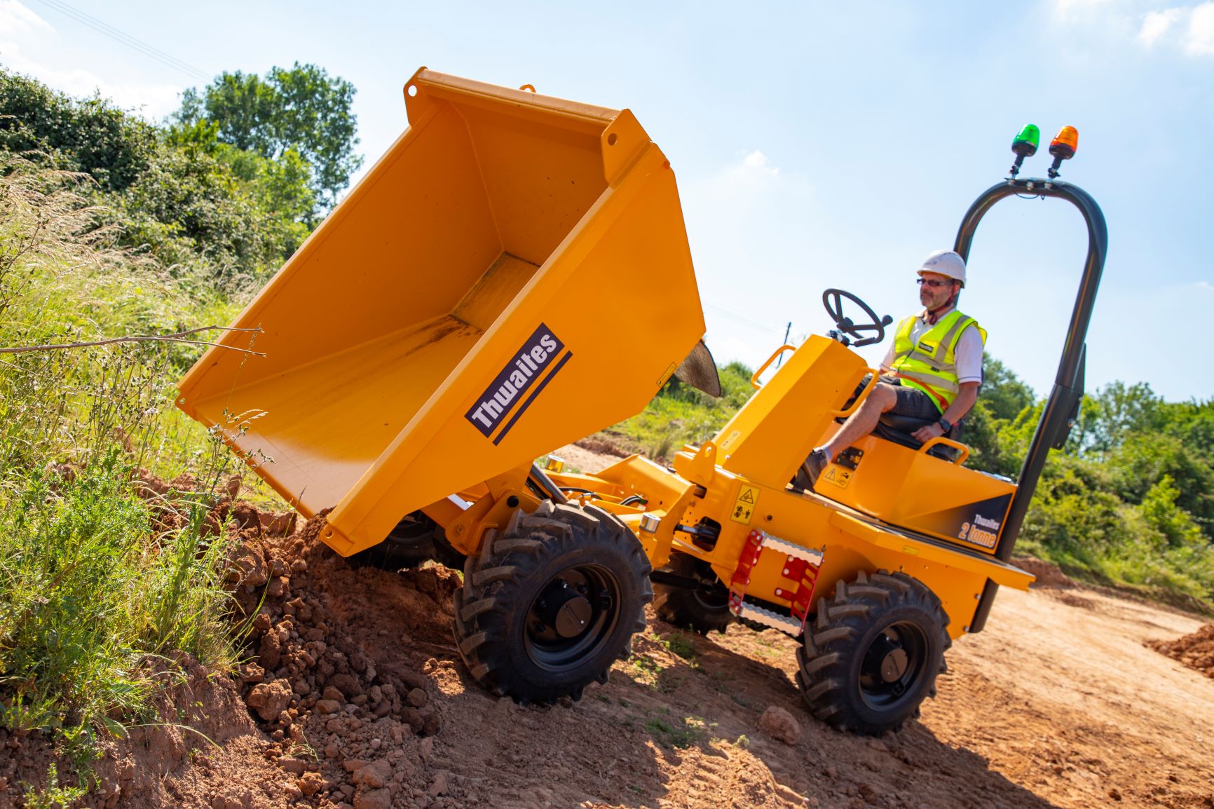 Thwaites 2 tonne front tip dumper, being operated with skip extended and tipping mud out onto the ground