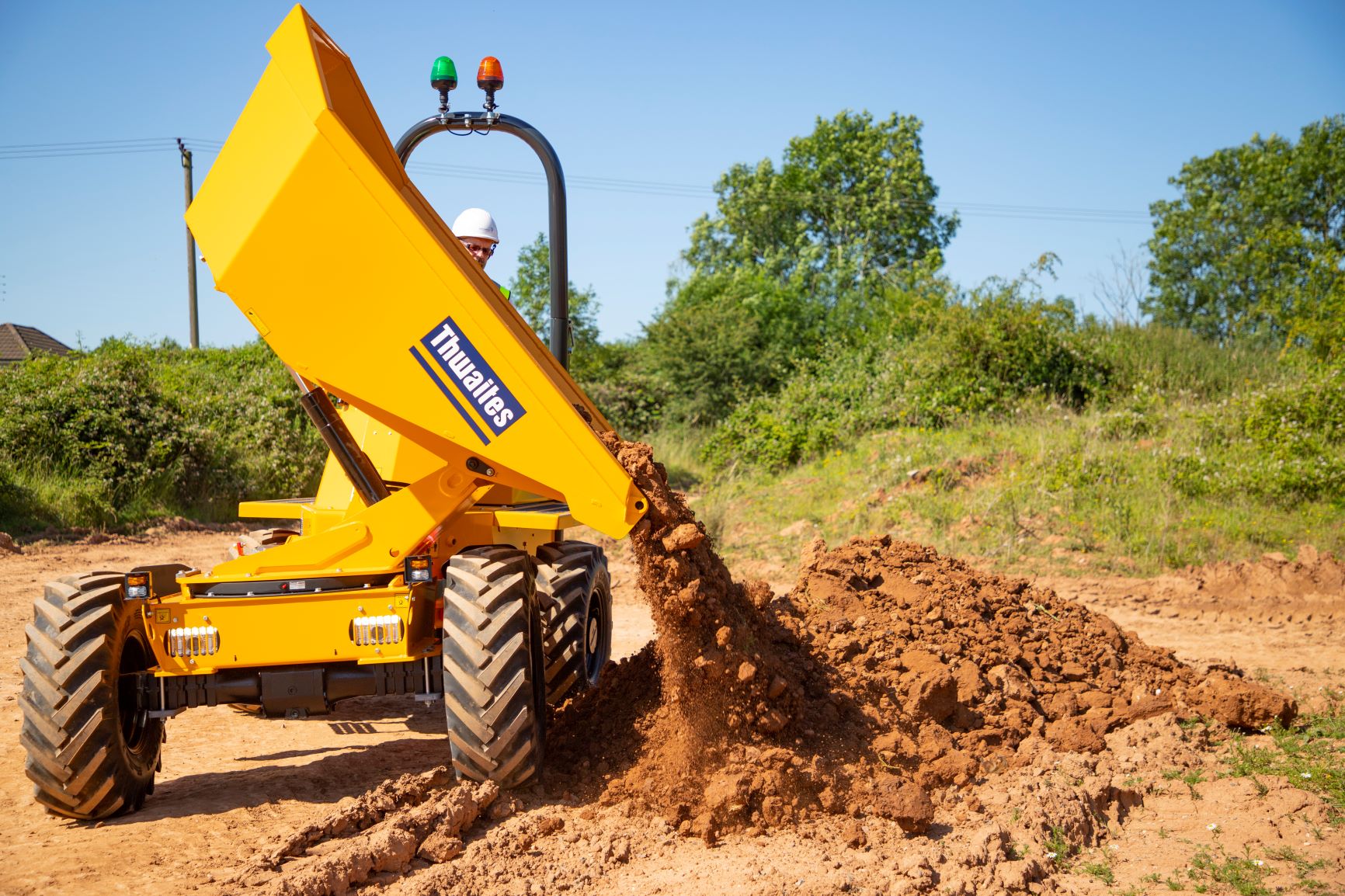 Thwaites 3 tonne dumper power swivel, emptying the skip of soil onto the ground Thwaites 3 tonne dumper power swivel, emptying the skip of soil onto the ground